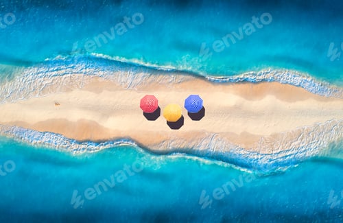 Preview: Aerial view of blue sea on both sides and beach with umbrellas