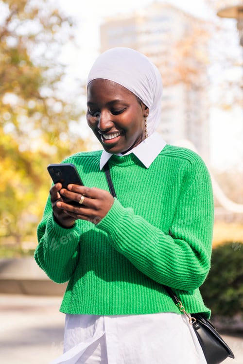 Preview: black woman smiling happy using her mobile phone