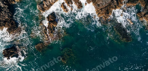 Preview: A dangerous sea wave crashes into the rocky coast with spray and foam before the storm.