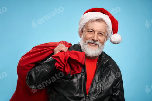 Preview: Mature man in Santa hat and leather jacket with red sack