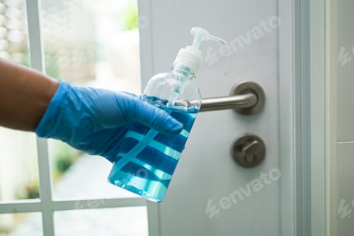 Preview: Cleaning door handle with alcohol at office and home for protect covid 19 coronavirus.