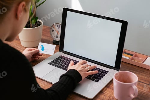 Preview: Woman using laptop and credit card for online shopping, partiel view