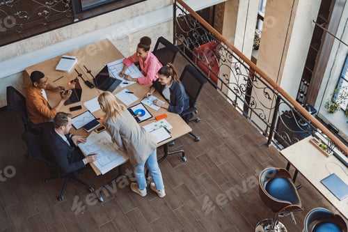 Preview: Diverse corporate team working together in meeting room. Colleagues collaborating on new project