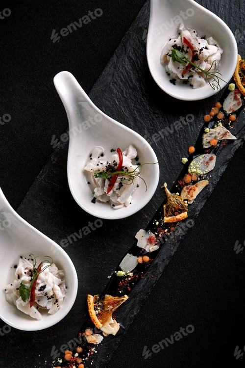Preview: Sea bass ceviche mini portions served in beautiful Chinese spoons on a black plateau. Food concept