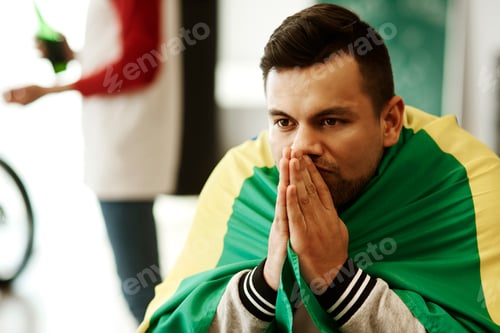 Preview: Nervous football fan with flag praying