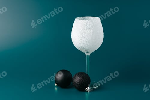 Preview: Decorative snow-covered frosted wine glass on green background