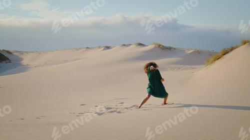 Preview: Modern dancer performing desert dunes summer day in distance. Girl dancing.