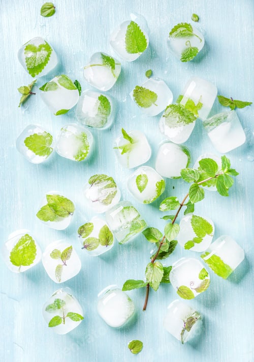 Preview: Ice cubes with frozen mint leaves inside on blue Turquoise background