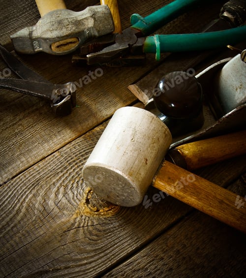 Preview: Many old working tools ( mallet, pliers and others) on a wooden background.