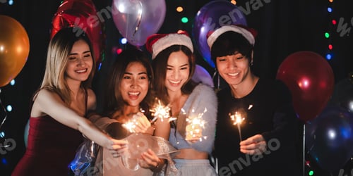 Visualização: Amigos felizes comemorando com cintilantes, fogos de artifício e coquetéis em casa