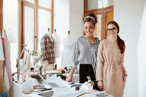 Preview: Two women stylists in design studio. Work process of modeling new clothes