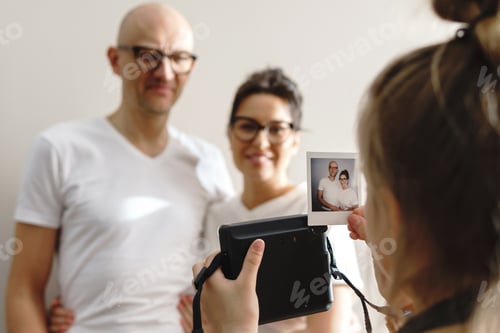 Preview: Girl made a photo of her parents with a instant camera