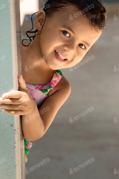 Preview: Smiling toddler girl in swimwear looking at camera, summer vacation and childhood concept