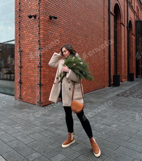 Preview: Stylish Woman Holding Evergreens in Urban Setting