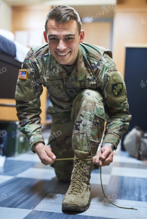 Preview: Shot of a young soldier tying his boot shoelaces in the dorms of a military academy