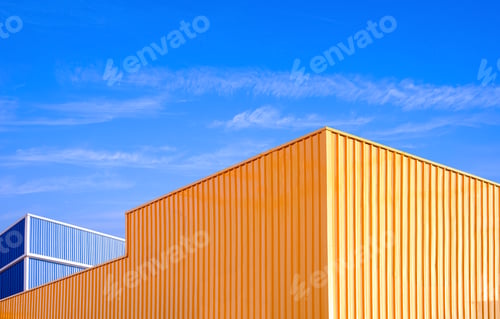 Preview: Colorful yellow and blue geometric industrial warehouse factory buildings against blue sky