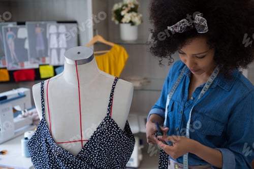 Preview: Fashion designer designing a dress on mannequin