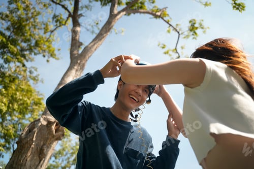 Preview: Cheerful young people enjoying outdoor fun while listening to music under a sunny sky