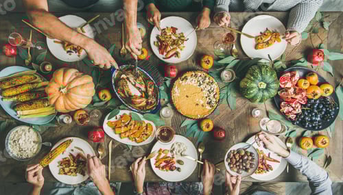 Preview: Friends feasting at Thanksgiving Day table with turkey and wine