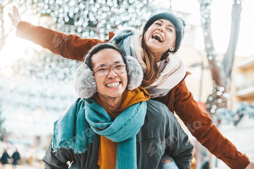 Preview: Multiracial couple in love wearing winter clothes celebrating Christmas holiday