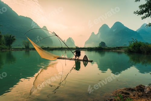 Preview: Villager with traditional fishing on bamboo raft over the river in misty morning at Phong Nam Valley