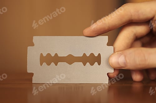 Preview: man's hand holding empty business card in the form of a blade for beauty salon, barbershop