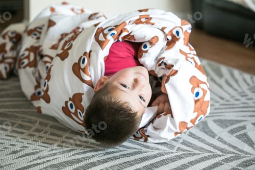 Preview: Mischief and play of young boy in bed before going to sleep. Guy is wrapped in a blanket