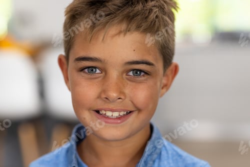 Preview: Closeup portrait of caucasian cute boy with gray eyes and blond hair smiling at home, copy space