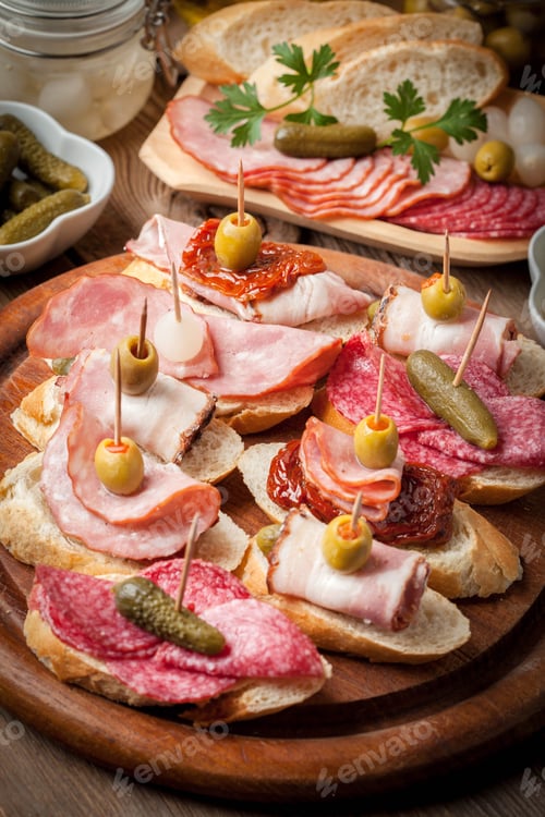 Preview: Tapas with sliced sausage, salami, olives and parsley.