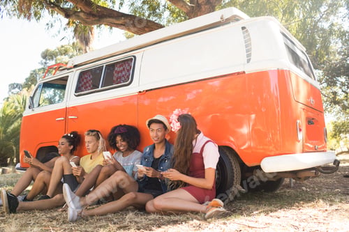 Preview: Happy fiends using phone while sitting on field