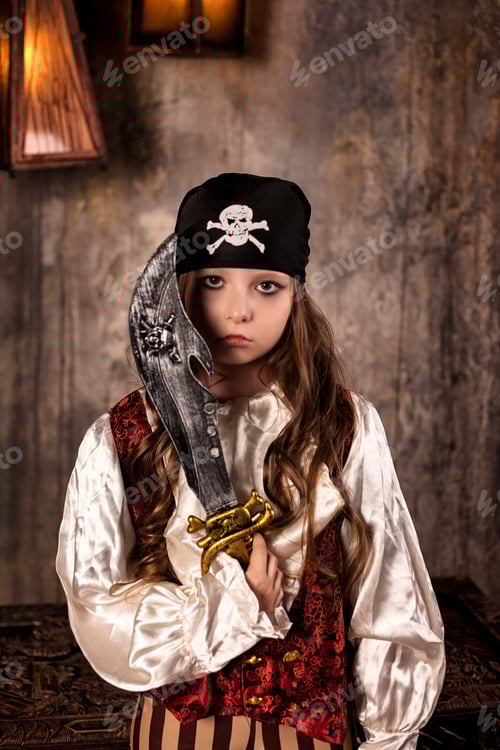 Preview: Serious little girl actress 7-8 year old in pirate's image with saber at grey textured wall