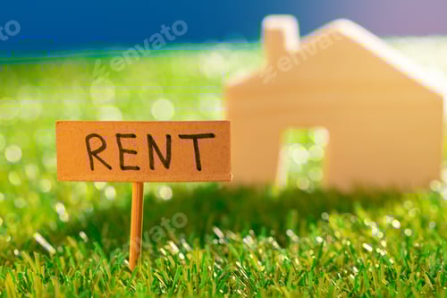 Preview: Wooden toy house with rent sign on grass