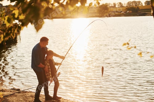 Preview: With catch. Father and son on fishing together outdoors at summertime
