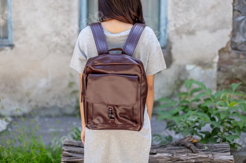 Preview: Back of woman with brown leather backpack