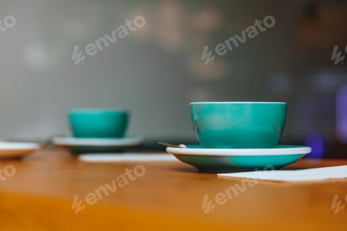 Preview: Greenery cups of hot coffee on wooden table in cafe