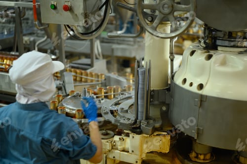 Preview: Factory employee wearing protective clothes managing canning process in factory