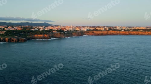 Preview: Aerial view coastal resort town with calm ocean. Building complex on stone cliff