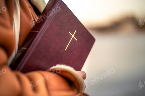Preview: A woman holds the Bible in her hands in nature. Christianity concept.