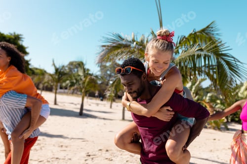 Preview: Happy diverse friends walking at beach