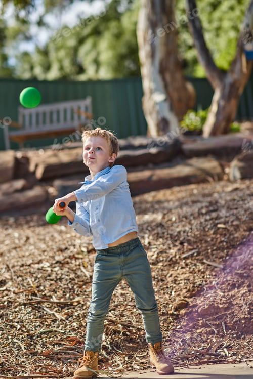 Preview: Boy in garden playing with foam baseball bat and ball