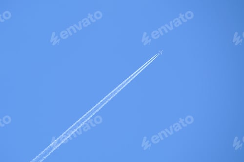 Preview: Distant passenger jet plane flying on high altitude on clear blue sky leaving white smoke trace of