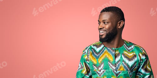 Preview: Positive black man in african shirt looking at copy space
