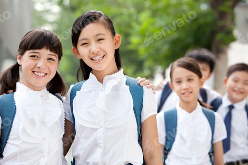 Preview: Happy Chinese schoolgirls in uniform with friends outdoors