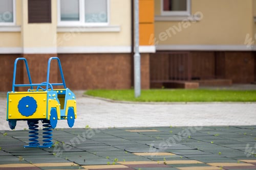 Preview: Kindergarten playground with bright toy car on spring. Children activities and recreation outdoors