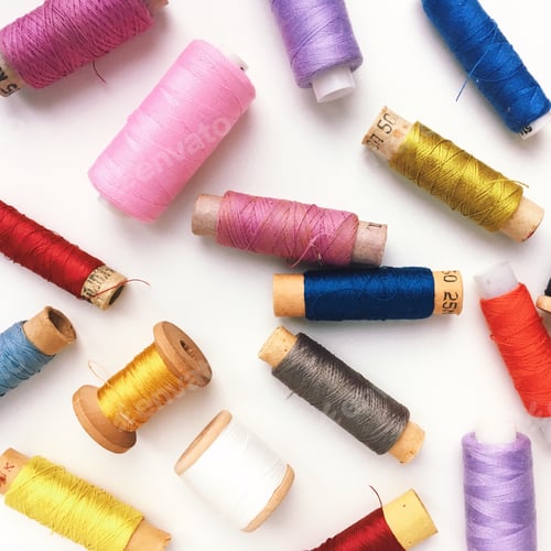 Preview: Colored sewing threads on a white background