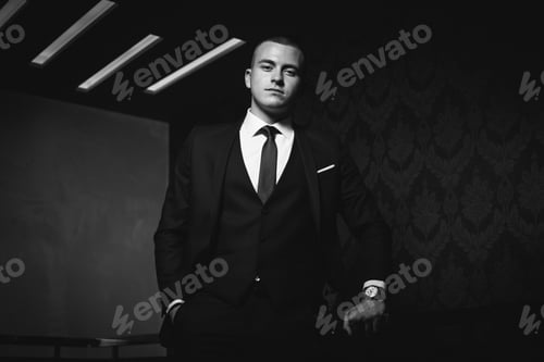 Preview: Closeup shot of a white Caucasian man wearing a classic black suit and posing for a picture