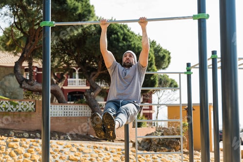 Preview: Male athlete exercising on pull up bar