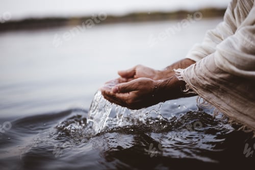 Preview: Closeup shot of a person's hands holding water with a blurred background
