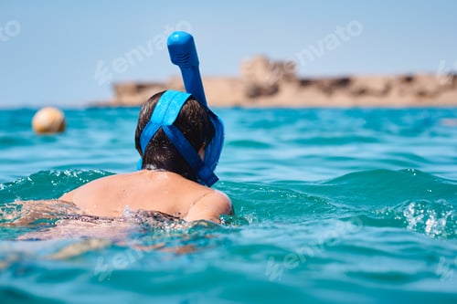 Preview: Woman with a snorkel full face mask diving in blue sea. Summer vacation