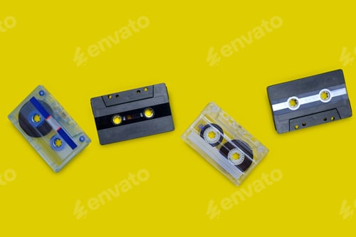 Preview: Old compact cassette tape on yellow background